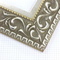 A large, reverse curve profile frame with an intricate leaf design bordered by a geometric outer edge and beaded inner lip.  A dark, matte Gold brown base with gold foil patina for added depth on the topmost points of the design. Strong, solid wood construction.

3.25 " witdth: ideal for large and oversize (extra large) images.